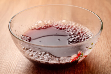 Hot water is poured into a bowl, in which green jelly is dissolved. Preparation of gelatin desserts.