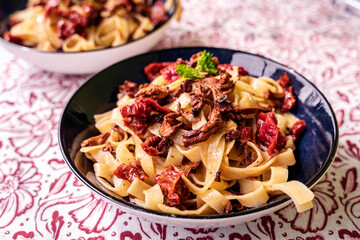 Tagliatelle pasta with chanterelle mushrooms, dried tomatoes and parsley
