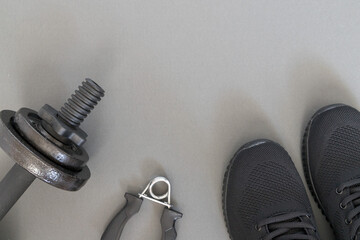Sports accessories for training and equipment for men on a gray background: weights, expander,...