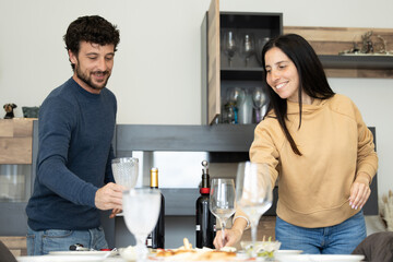 couple setting the table for lunch or dinner with guests. Cheerful caucasian couple setting cutlery for easter dinner.