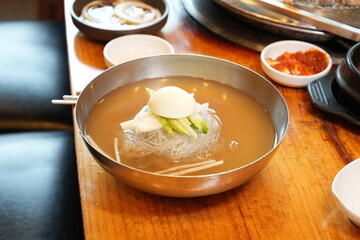 물냉면 한 그릇이 식탁 위에 놓여 있는 모습