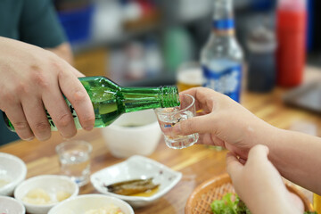 소주잔에 소주를 따라 주는 모습