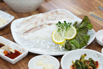 식탁 위에 활어회 한 접시가 놓여 있는 모습