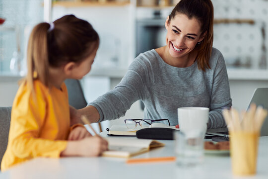 A caring mother encouraging her daughter for doing her homework successfully