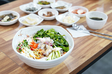 물회 한 그릇과 밑 반찬이 식탁 위에 놓여 있는 모습