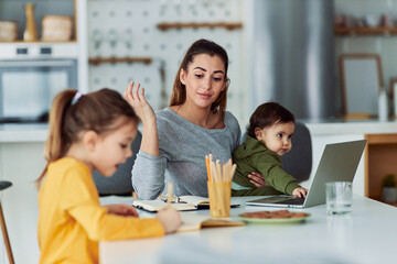 A single mother taking care of her children while working from home and reading her notes