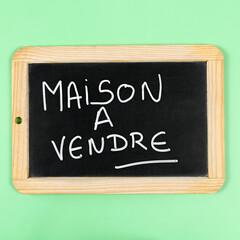 Obraz premium les mots maison à vendre écrit en français sur une ardoise
