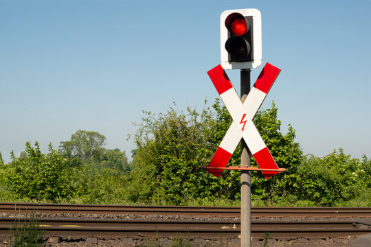 Andreaskreuz vor einer Bahn&uuml;bergang mit roter Ampel