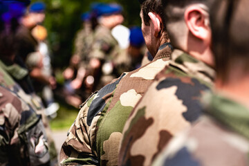 French soldier wearing camouflage uniform, close-up on his back with background