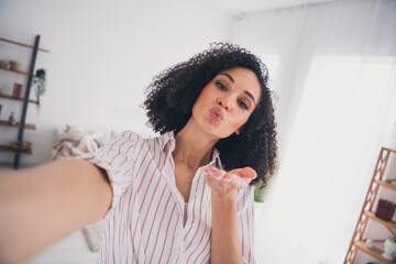 Photo of charming adorable lovely cute woman recording video shooting sending kiss room indoors