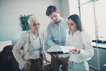 Obraz premium Photo of business people reading clipboard discussing report in modern office
