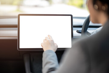 A woman is driving a car with a tablet in her lap