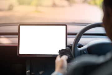 A person is driving a car with a tablet in the front seat
