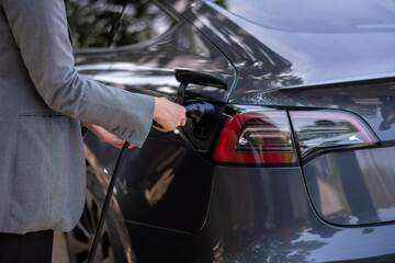 Fototapeta premium A woman is plugging in her car