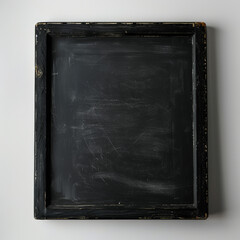 Fototapeta premium small black blank school blackboard with wooden frame on the wall, copyspace in the center, beginning or end of the school or university academic year
