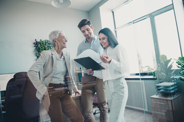 Photo of business people senior lady discussing document with man girl reading clipboard in...