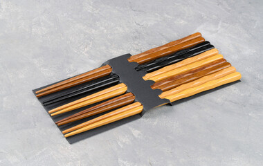 Wooden Chinese chopsticks in packaging on concrete background