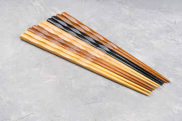 Several colorful Chinese chopsticks on a concrete background close-up