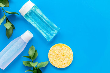 Organic cosmetics for face clearing with sponge, facial tonic and mycelial water on blue background...