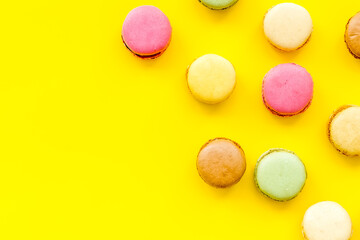 Macarons dessert pattern on yellow background top view copy space