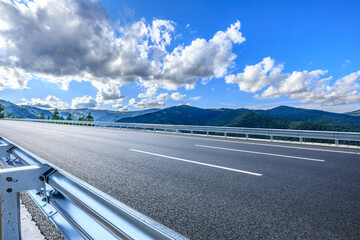 Fototapeta premium Asphalt highway road and green mountain with sky clouds natural background