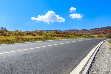 Asphalt highway road and grass with mountain nature landscape in autumn