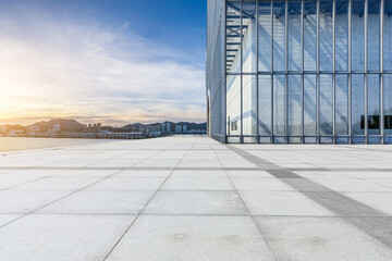 Obraz premium Empty square floor and glass wall with coastline at sunset