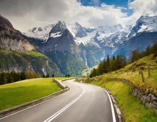 Fototapeta premium transport road in the Alps against the backdrop of snow-capped mountains and forest