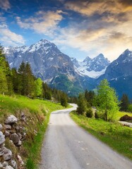 Obraz premium transport road in the Alps against the backdrop of snow-capped mountains and forest