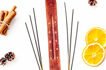 air freshener sticks with cinnamon and orange on white background top view