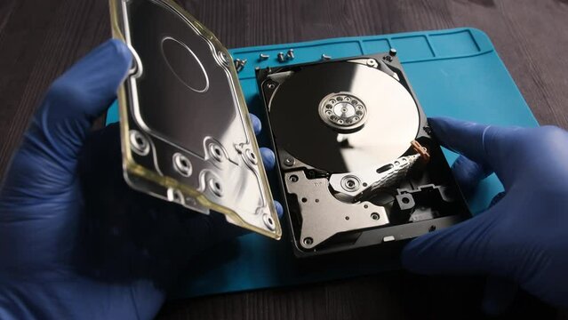 repairman fixing computer hard disk drive in service center