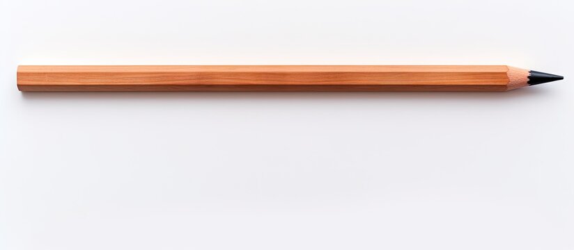 A blackboard and pencil made of wood are positioned alone on a white background allowing for a copy space image