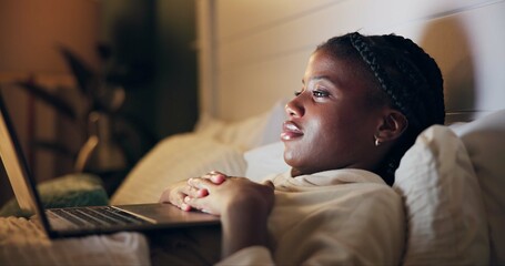 Bed, watch and black woman on laptop for movie streaming service, film or comedy at night. Girl at home relax in bedroom with computer for online TV show, series and funny video on weekend or holiday