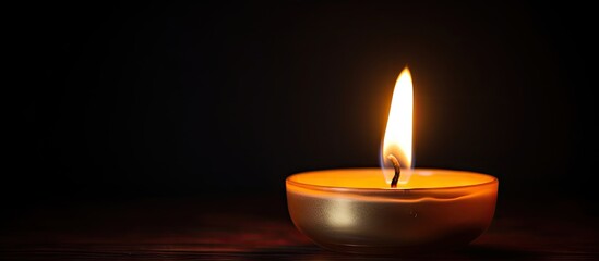 A beautifully lit wax candle burning against a dark background creates an enchanting ambiance Up close shot of the flickering flame at night offers a perfect copy space image