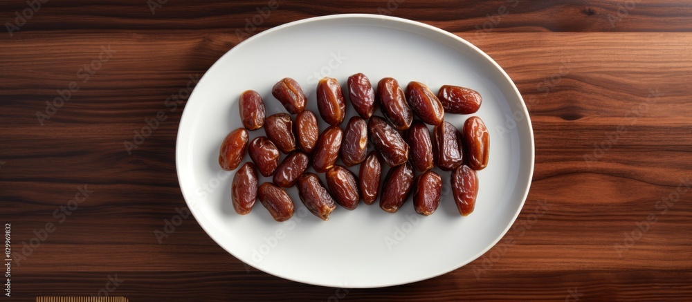 Aufkleber A copy space image of dates arranged on a white dish placed on a dark wooden table can be seen from a top down perspective