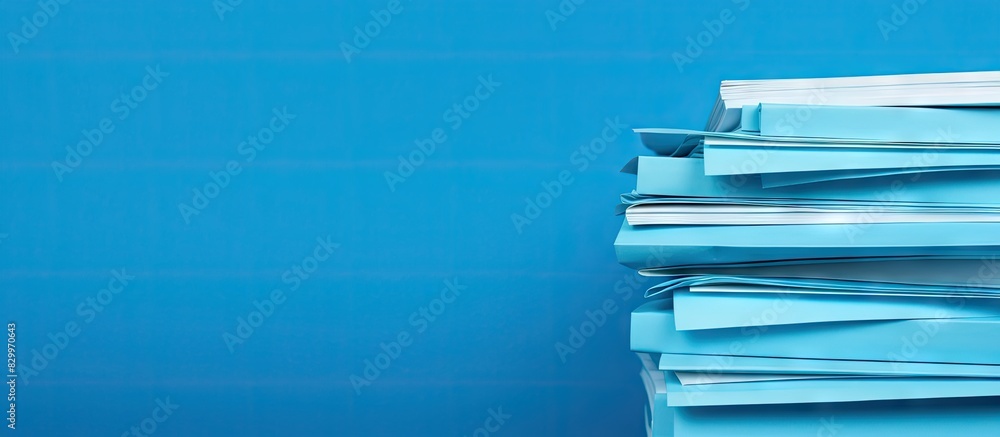Poster Blue background with multiple stacks of paper sheets arranged in a flat lay composition providing ample copy space for text