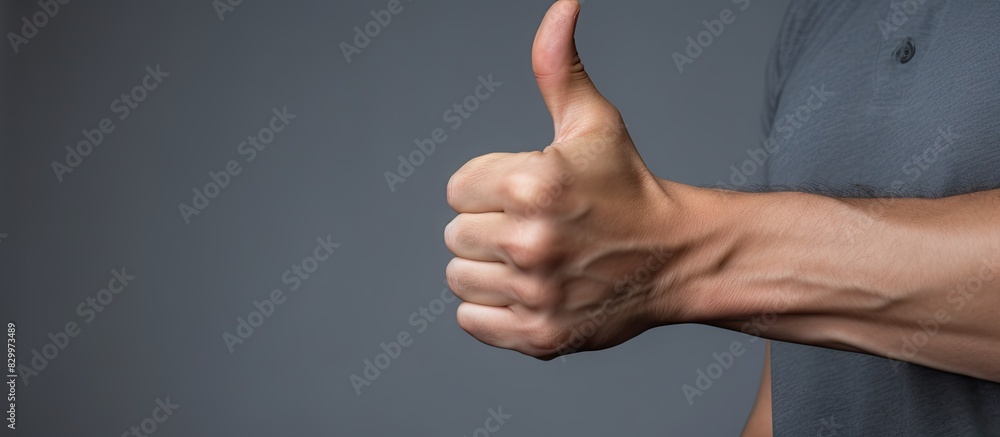Poster closeup of a man on a grey background giving a thumbs up gesture with copy space available for text