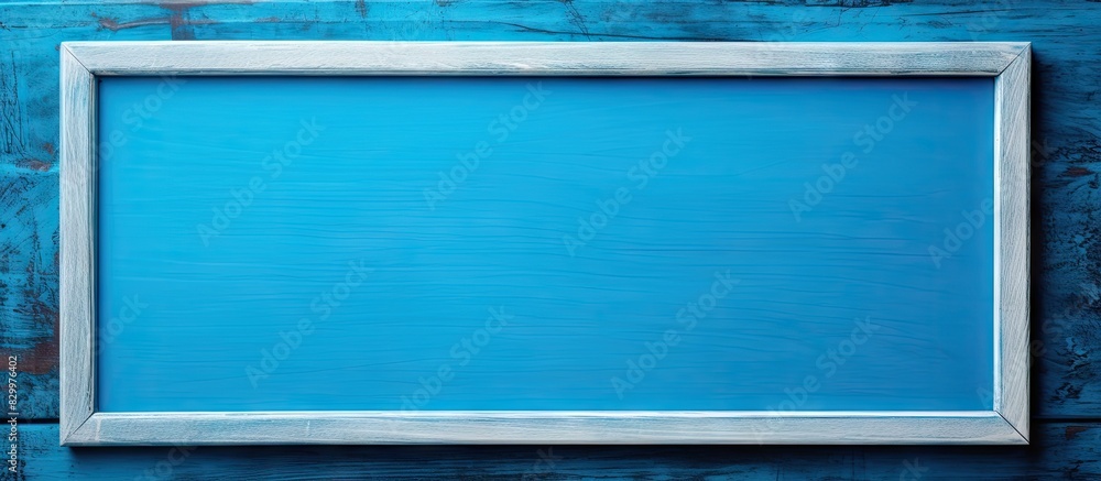 Poster A close up of an empty wooden frame on a blue background providing copy space for text The photo is of high quality