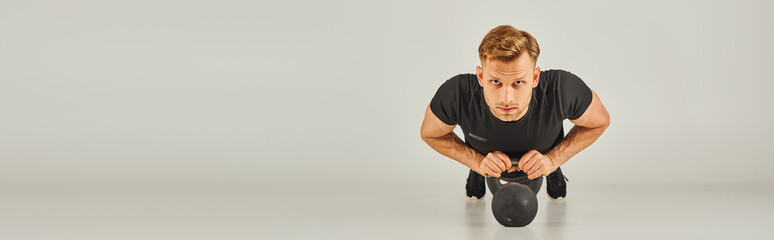 A man in a black shirt gracefully performing a squat on a white background in a studio, showcasing...