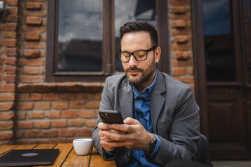 Adult man use mobile phone for text message or browse internet in cafe