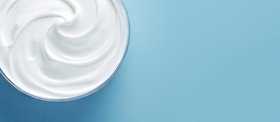 A delicious organic yogurt is displayed on a light blue surface with a top down perspective...