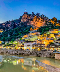 The 1000 windows of iconic Berat Albania. Evening lights from the city reflect on the river and the...