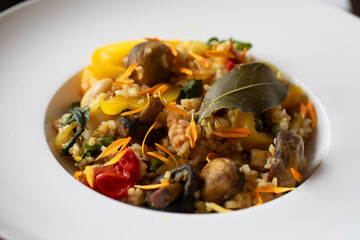 WHITE PORCELAIN DISH OF VEGAN RICE GARNISHED WITH EDIBLE FLOWER PETALS 