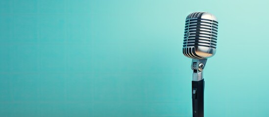 A modern microphone stands against a blue background leaving plenty of copy space in the image