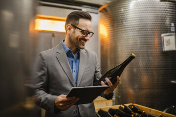 Adult man stand in basement hold bottle of wine and clipboard