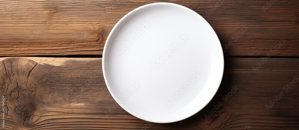 Poster a white dish sits on a wooden background with no other objects nearby allowing for ample copy space 