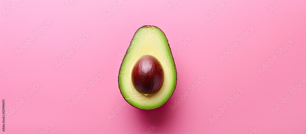 Poster a fresh avocado seen from above rests on a pink background leaving ample room for other elements in 