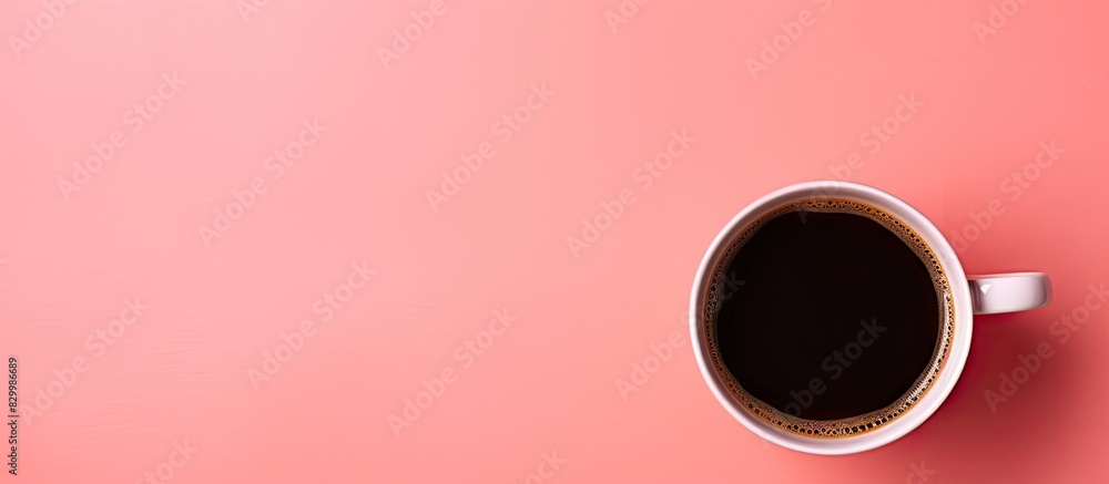 Poster a black coffee cup is seen from above on a pink background with ample space for additional imagery o
