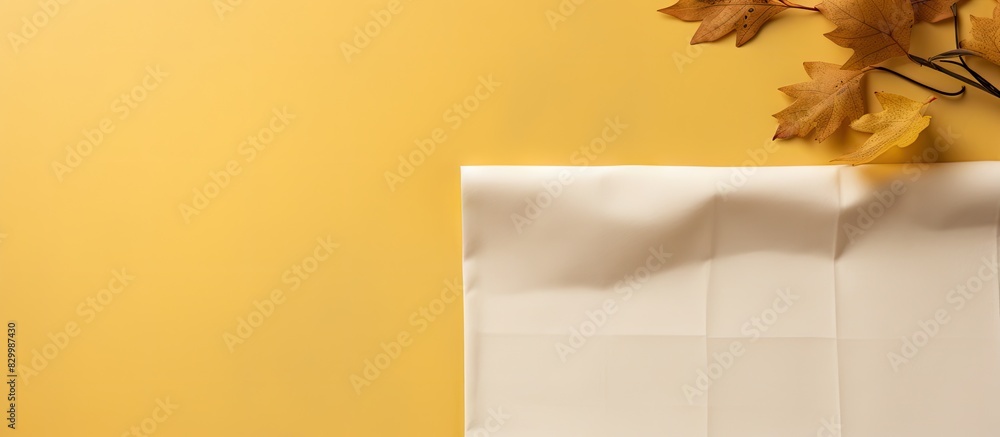 Aufkleber autumn foliage frames a blank calendar sheet setting the scene against a yellow textile backdrop in 