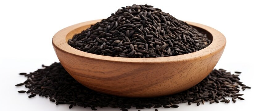 Copy space image of black cumin seeds presented in a wooden bowl isolated on a white background The pile showcases nigella sativa seeds captured from various angles creating a diverse and visually ap